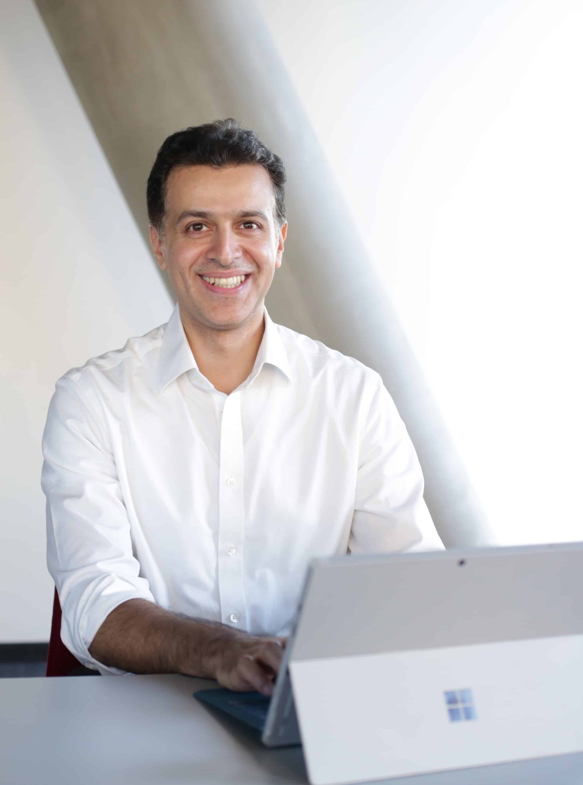 Esam Baboukhan sitting on a chair facing a laptop